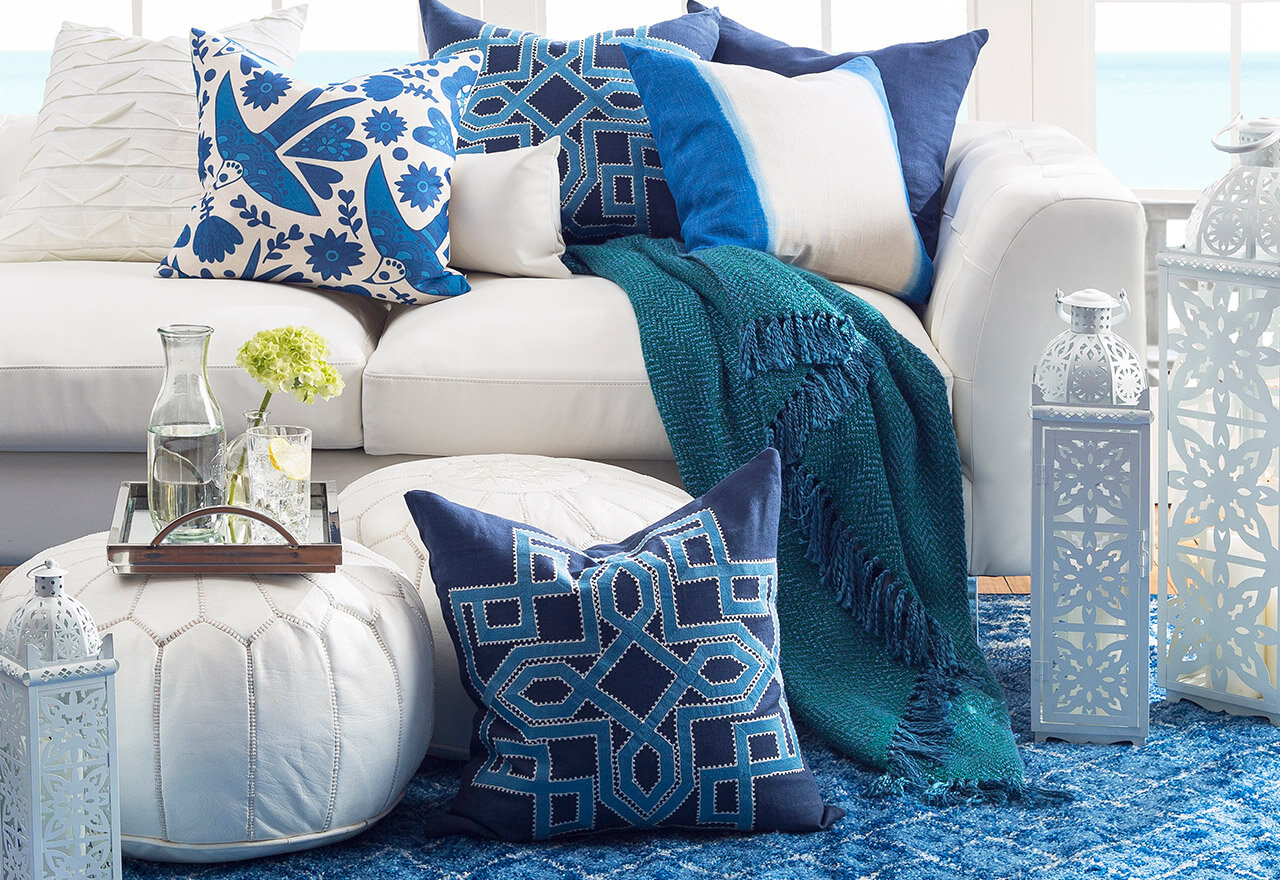 ue+throw+pillows+perched+atop+white+poufs+and+sofa.jpg